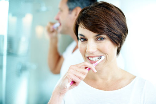 Woman and man brushing their teeth.