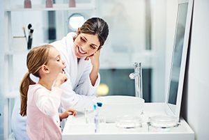 mother and daugther brushing their teeth