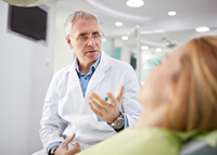 Dentist talking with reclining patient about IV nutrition