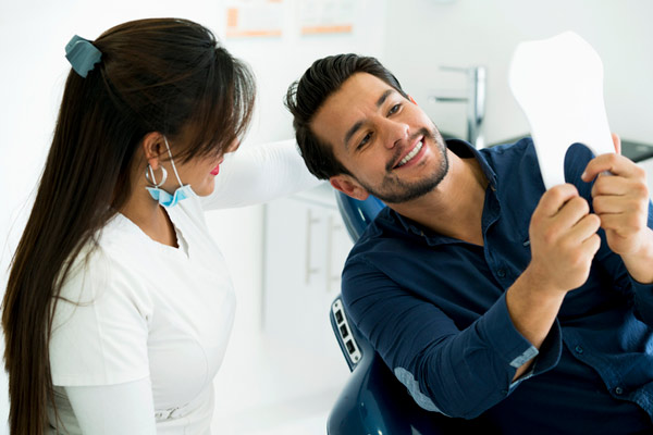 Patient looking at their teeth with their dentist.