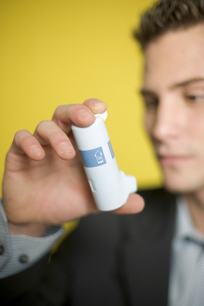 A man holding an asthma inhaler.