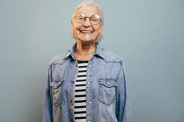 Elderly woman smiling confidently, highlighting the importance of oral health for overall wellness at any age.